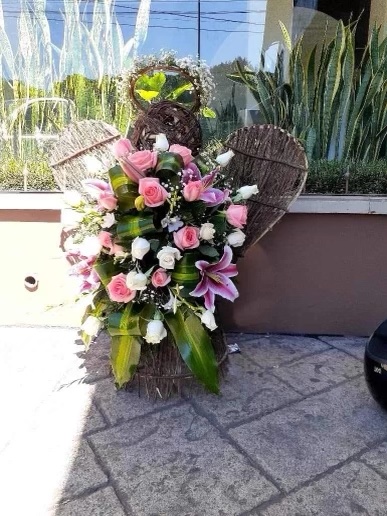 An image of pink and white roses made into an arrangement of an angel