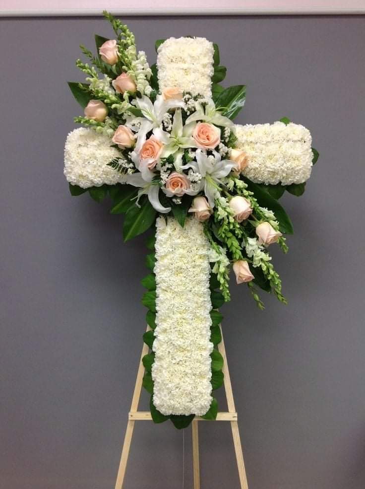 An image of a white cross with pink roses