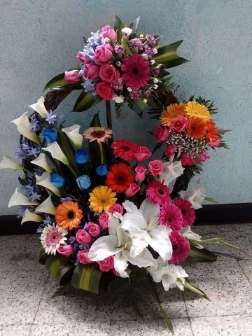 An image of multicolored flowers arranged in a basket 