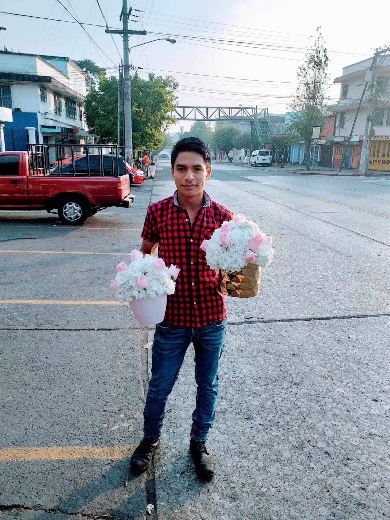 A picture of a man holding pink and white roses